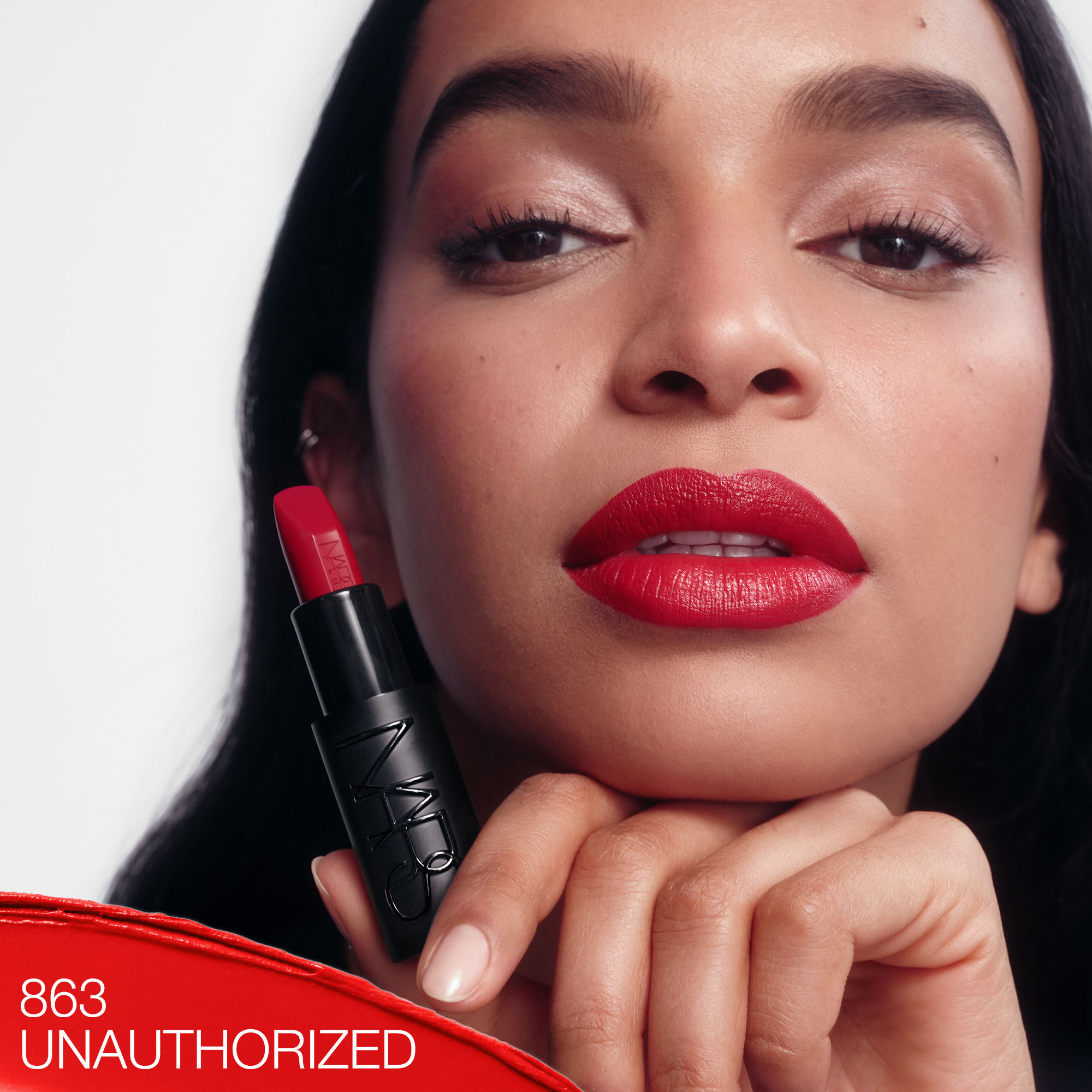 Model wearing NARS Explicit Lipstick in Unauthorized, a classic red